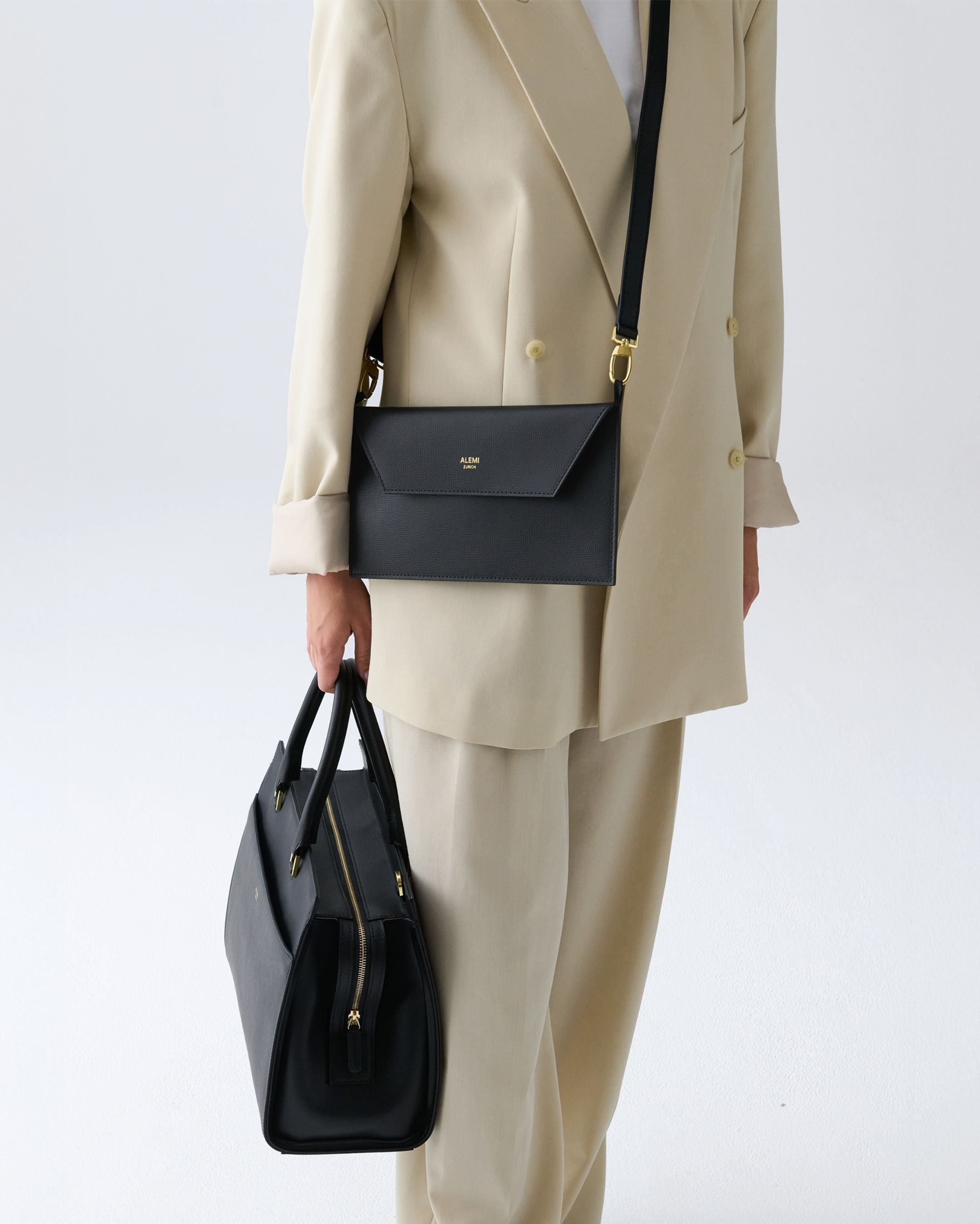 ALEMI Zurich | CENTRAL | Laptop Bag | Black | Pebbled Leather | Model carrying bag by handle close up