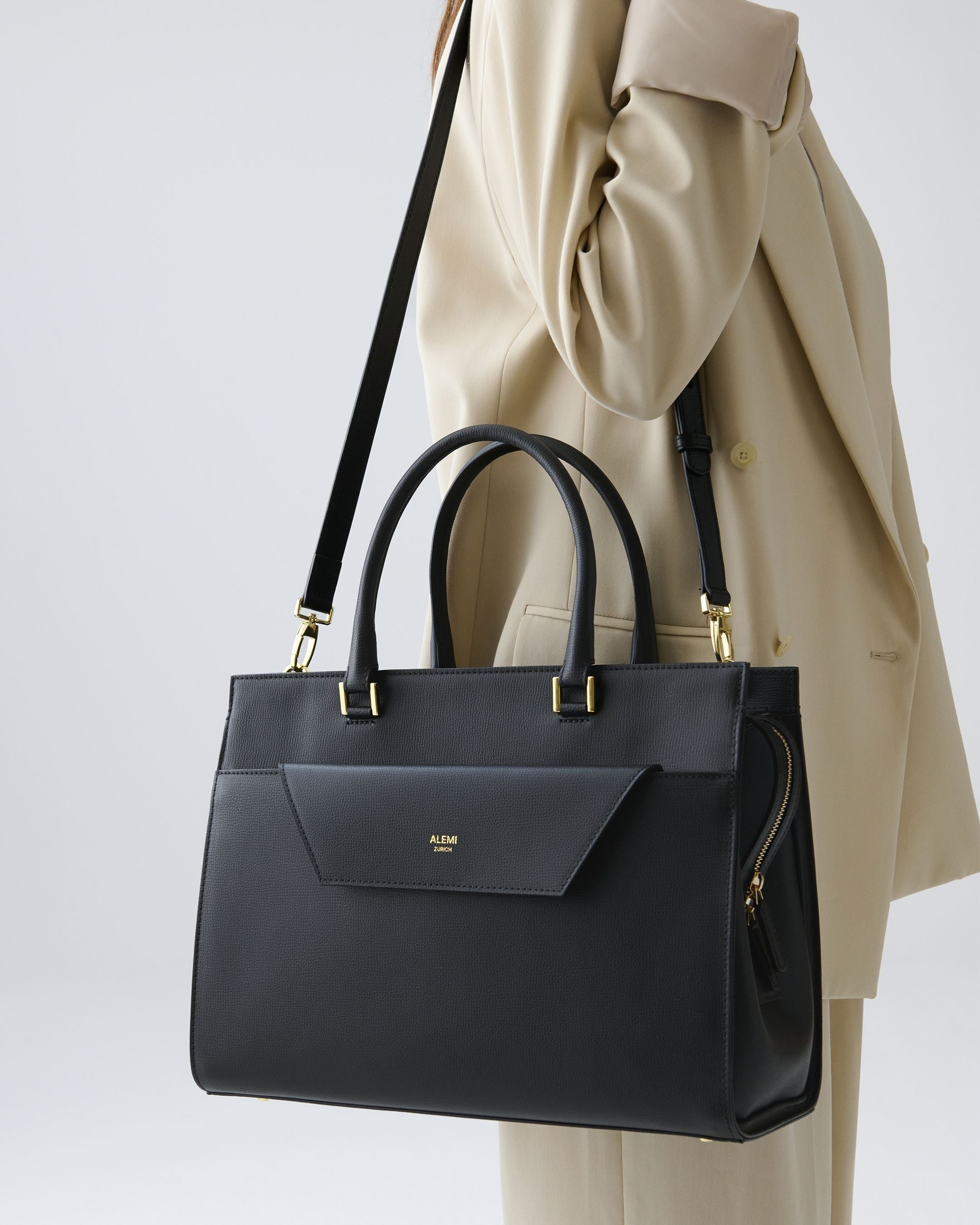 ALEMI Zurich | CENTRAL | Laptop Bag | Black | Pebbled Leather | Model carrying bag by strap