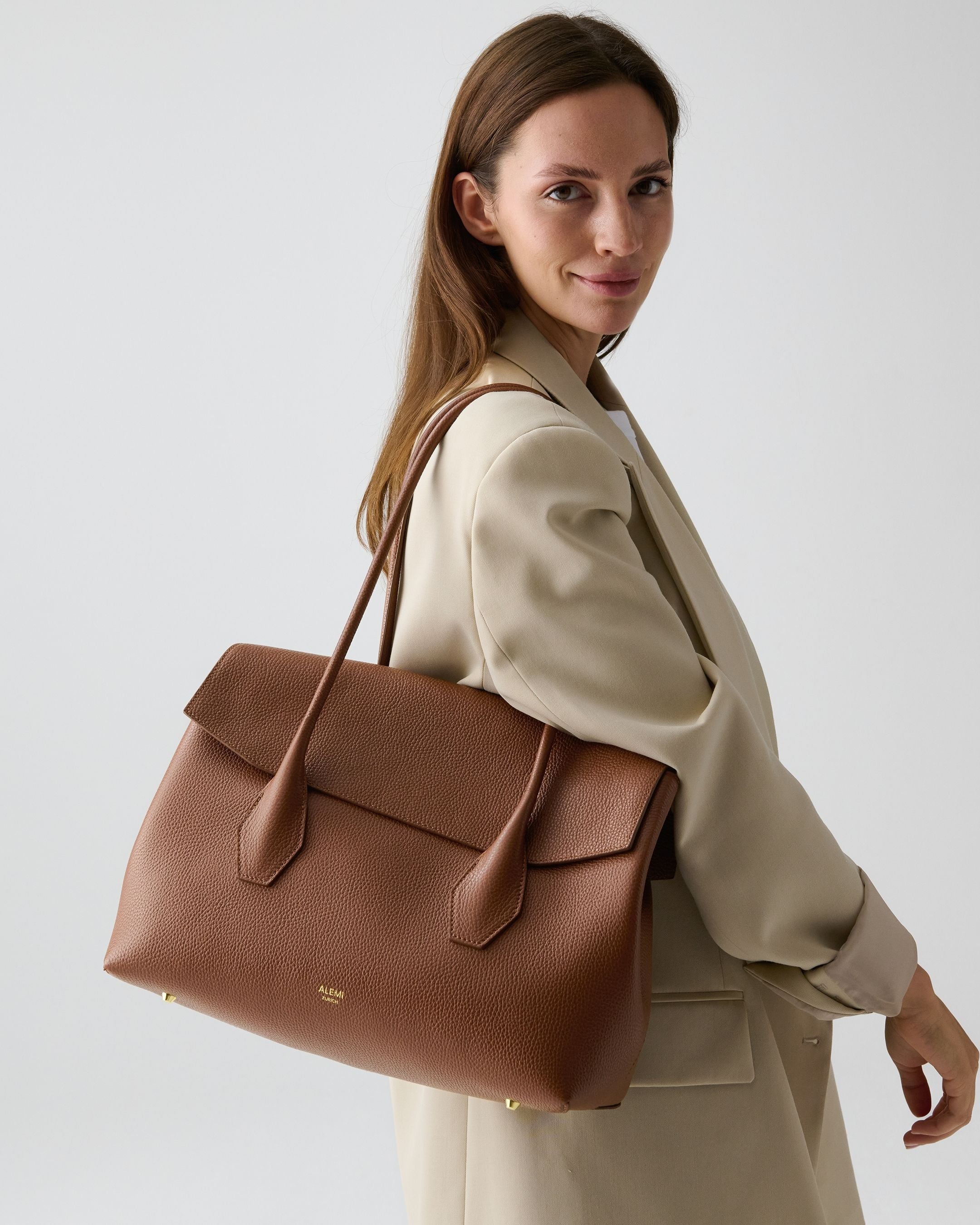 ALEMI Zurich | IDA | Laptop Bag | Cognac | Soft Grain Leather | Model carrying bag on shoulder