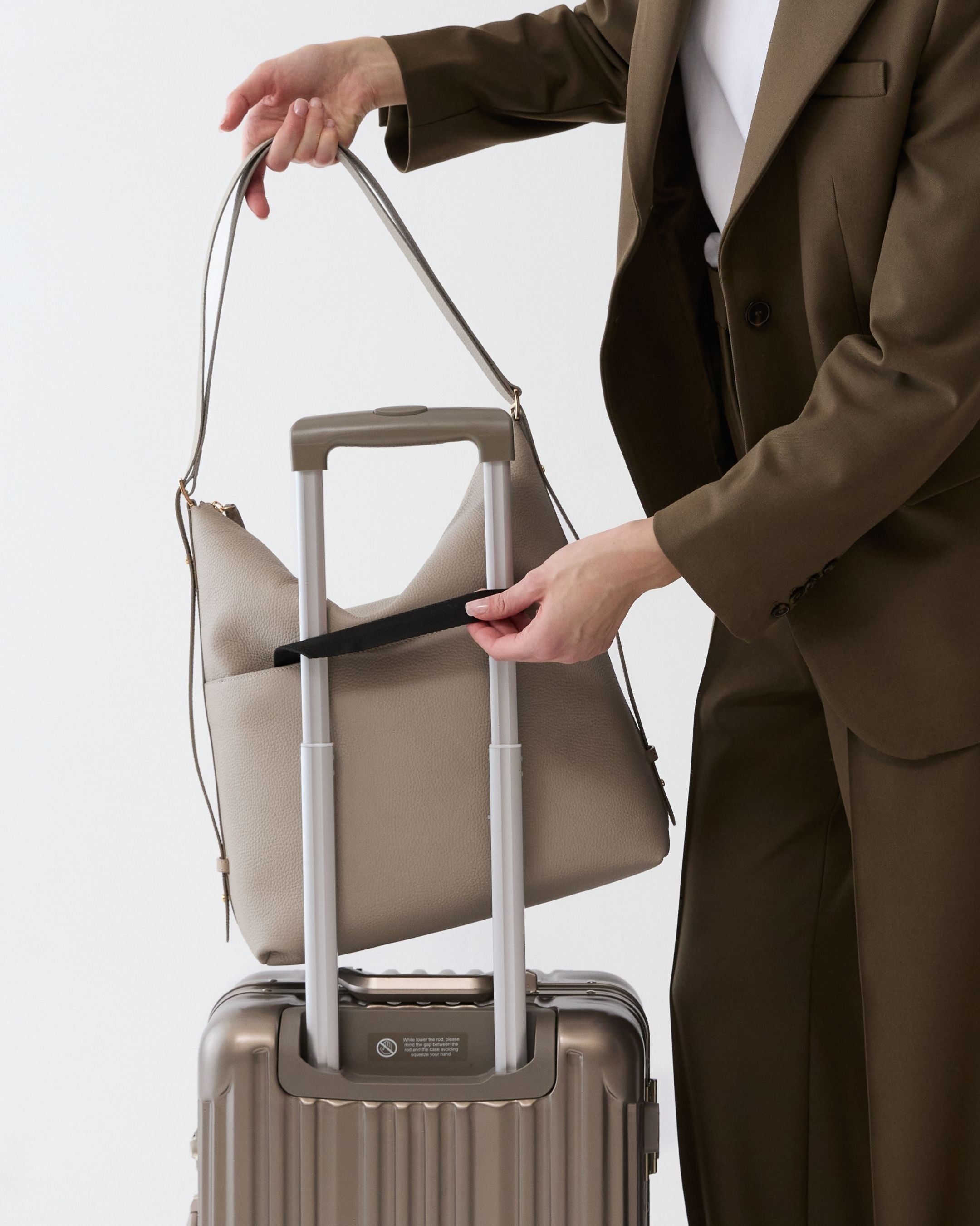 ALEMI Zurich | LETTEN | Laptop Bag | Beige | Soft Grain Leather | Bag on suitcase