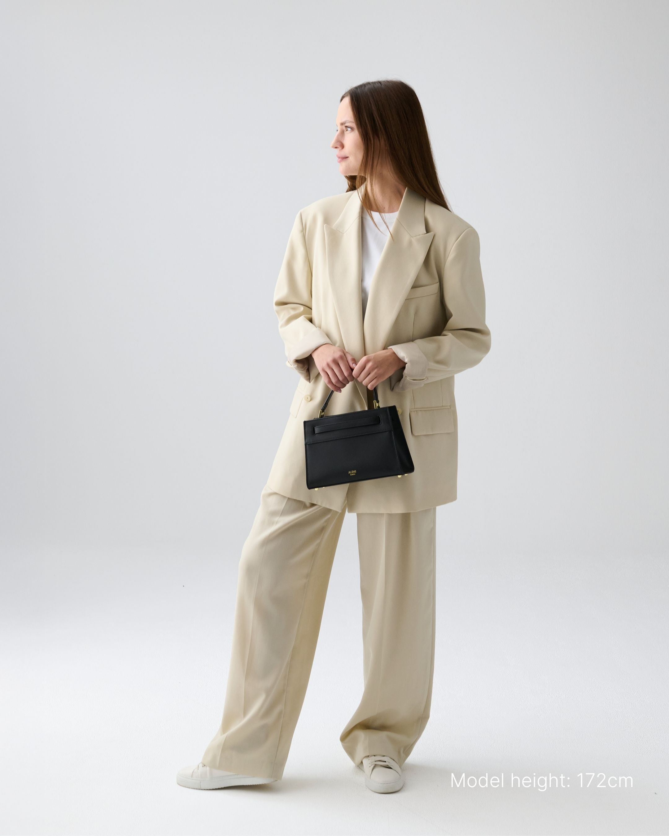 ALEMI Zurich | SEEFELD MINI | Small Bag | Black | Pebbled Leather | Model carrying bag by handle