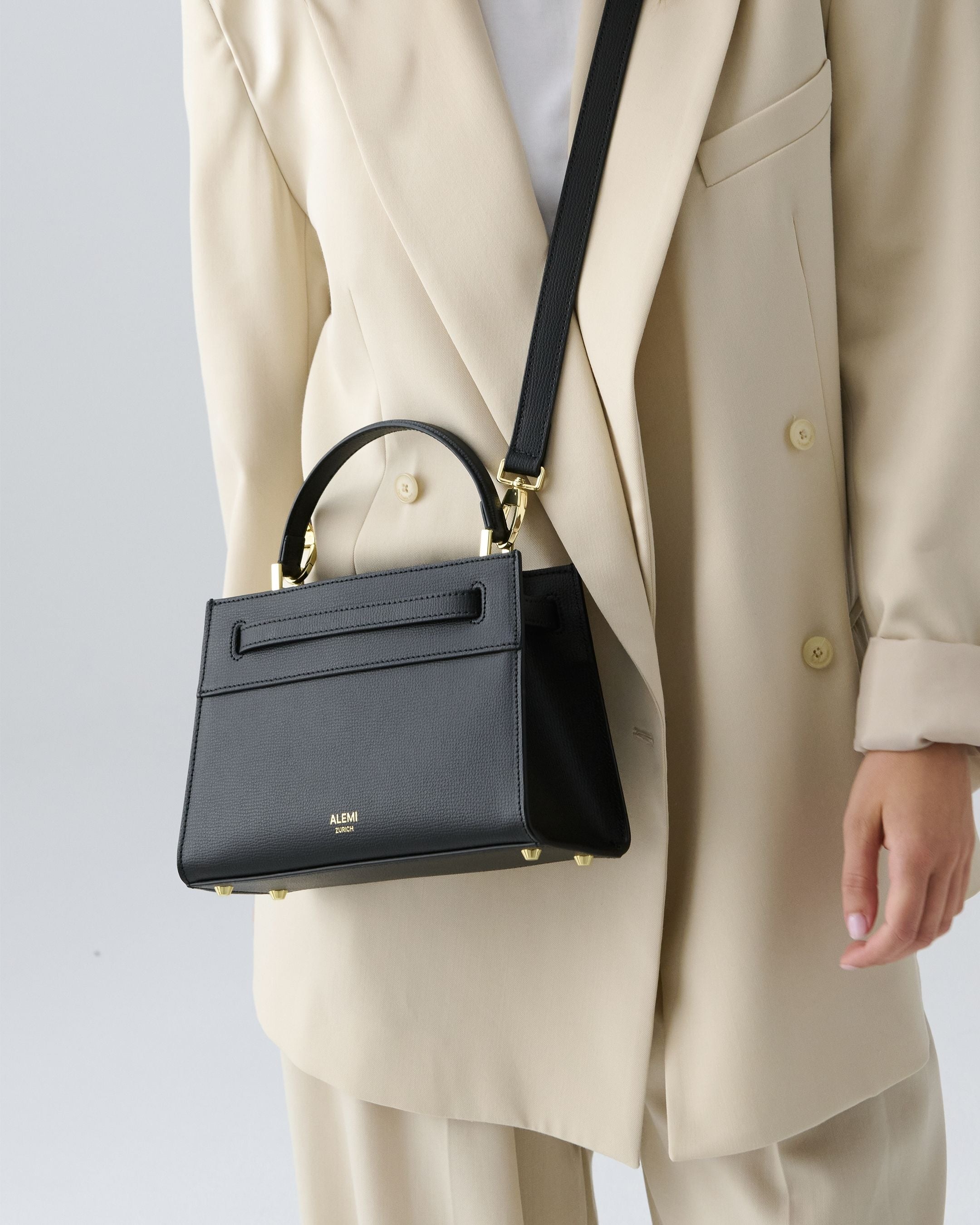 ALEMI Zurich | SEEFELD MINI | Small Bag | Black | Pebbled Leather | Model carrying bag by strap