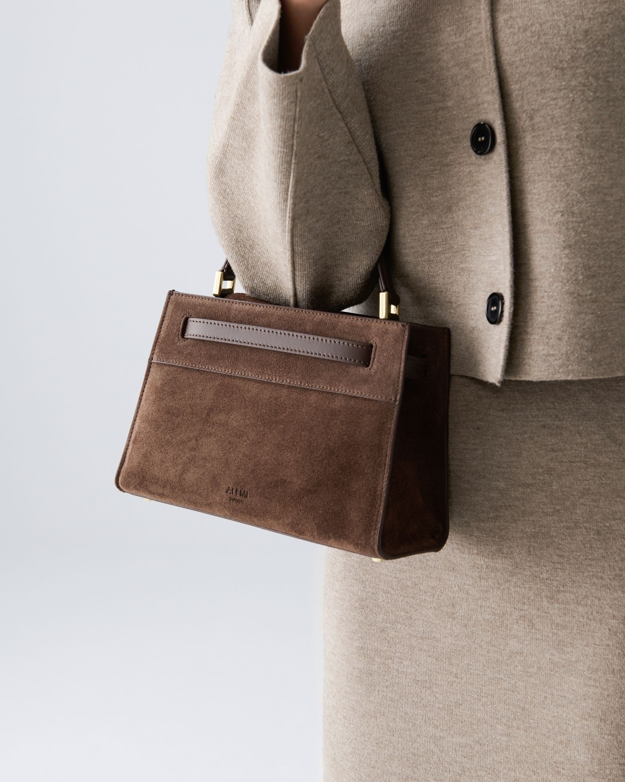 ALEMI Zurich | SEEFELD MINI | Small Bag | Dark Brown | Suede Leather | Model carrying bag by handle close up