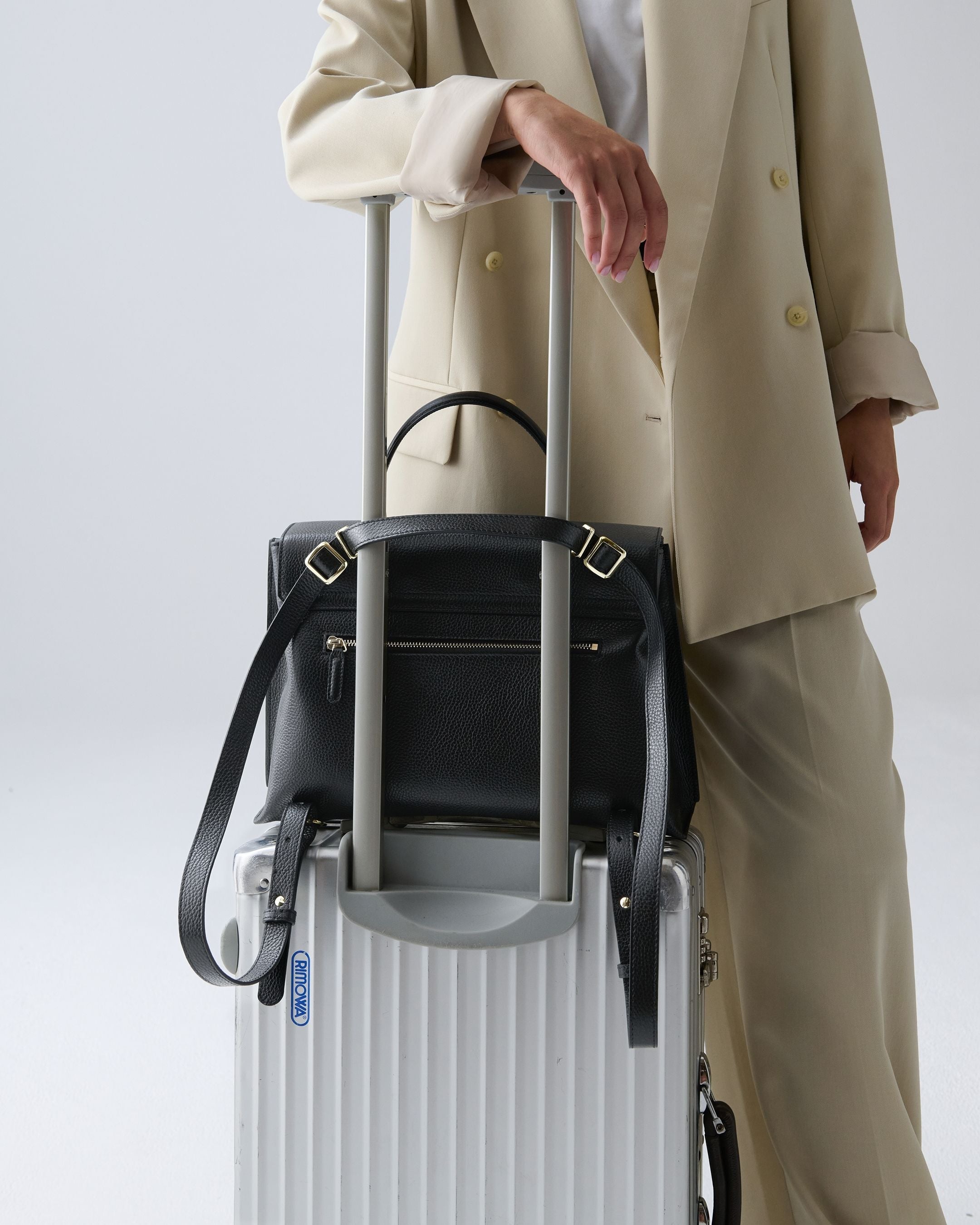 ALEMI Zurich | VIADUKT DAY | Laptop Bag | Black | Soft Grain Leather | Model carrying bag on suitcase