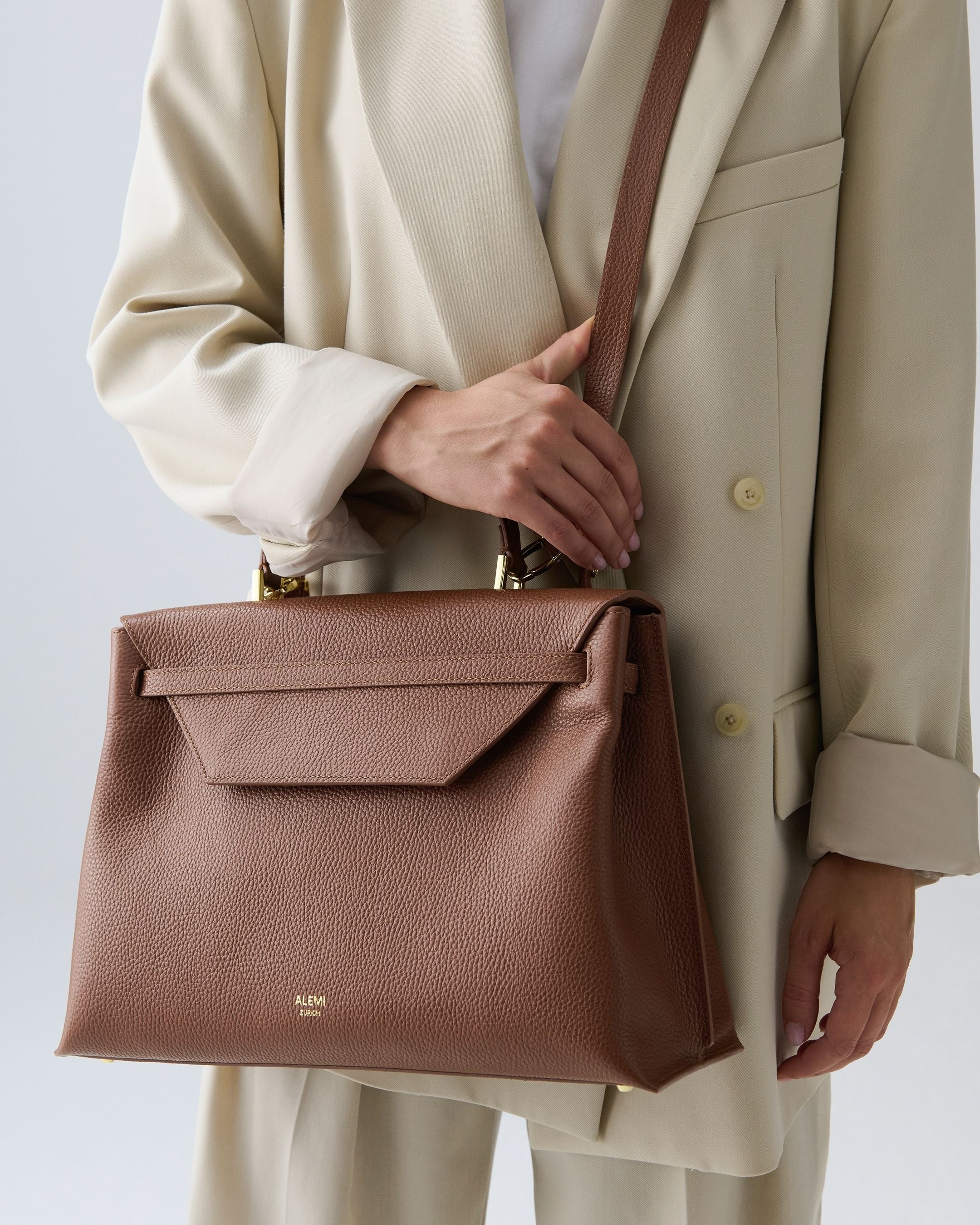 ALEMI Zurich | VIADUKT DAY | Laptop Bag | Cognac | Soft Grain Leather | Model carrying bag by strap
