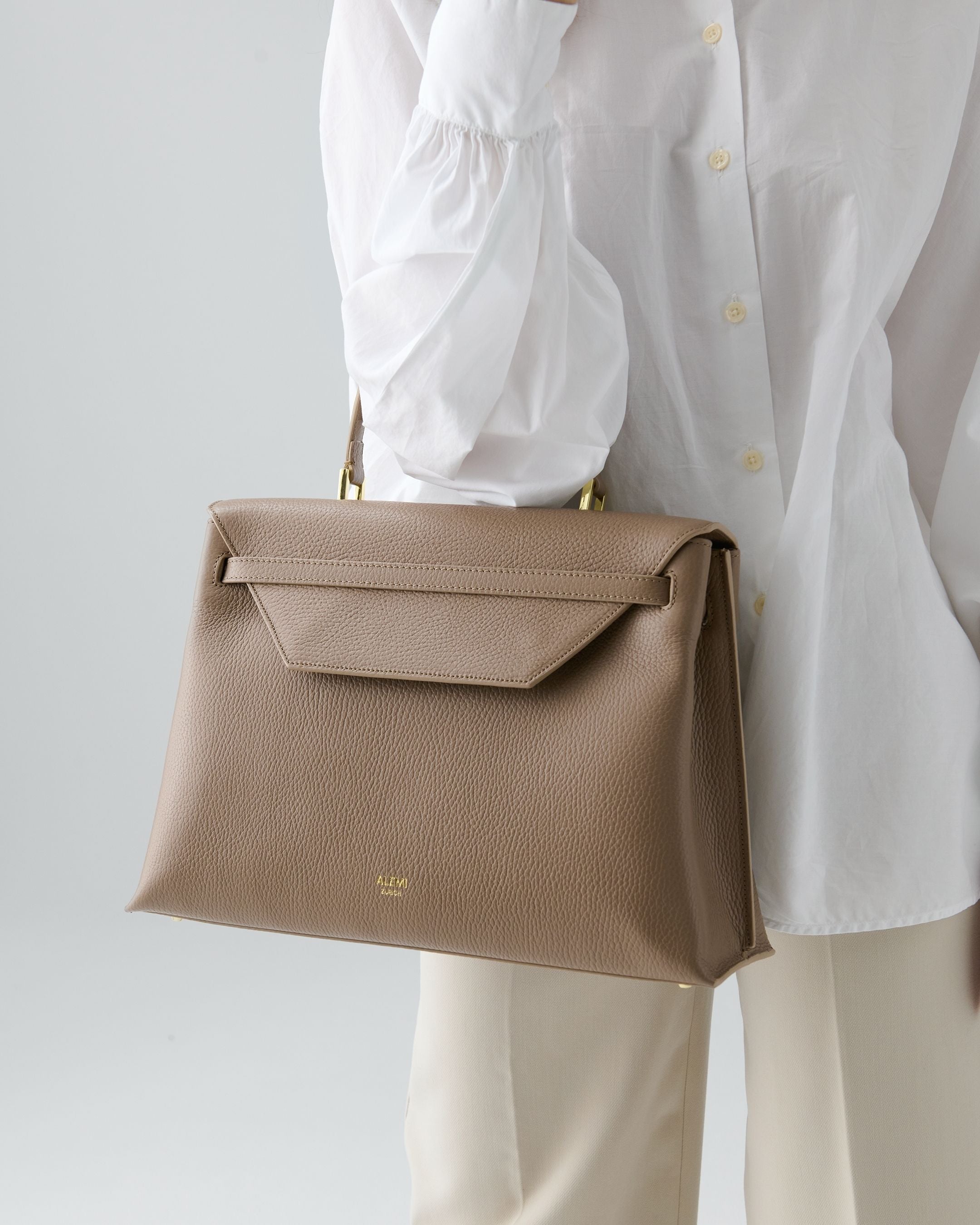 ALEMI Zurich | VIADUKT DAY | Laptop Bag | Greige | Soft Grain Leather | Model carrying bag by handle