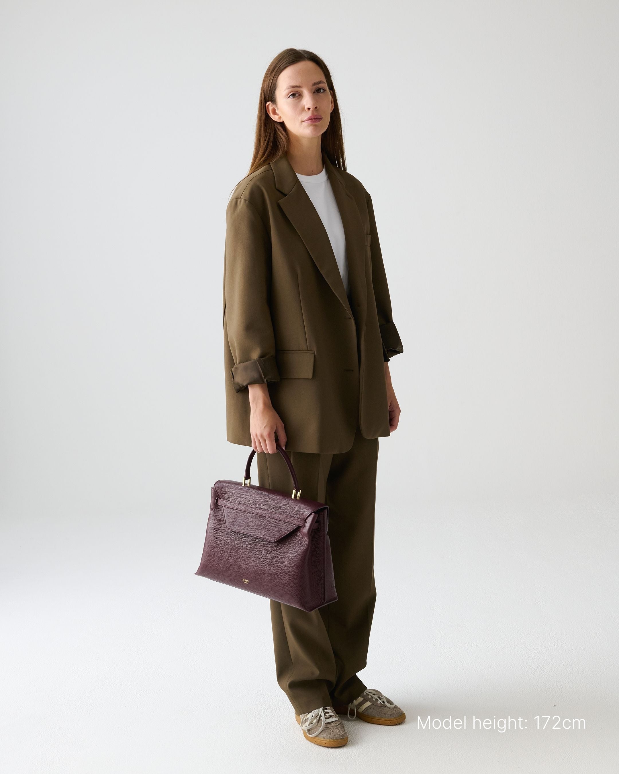 ALEMI Zurich | VIADUKT DAY | Laptop Bag | Maroon Red | Soft Grain Leather | Model carrying bag by handle